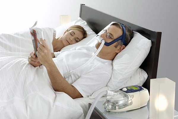 man wearing CPAP mask in bed