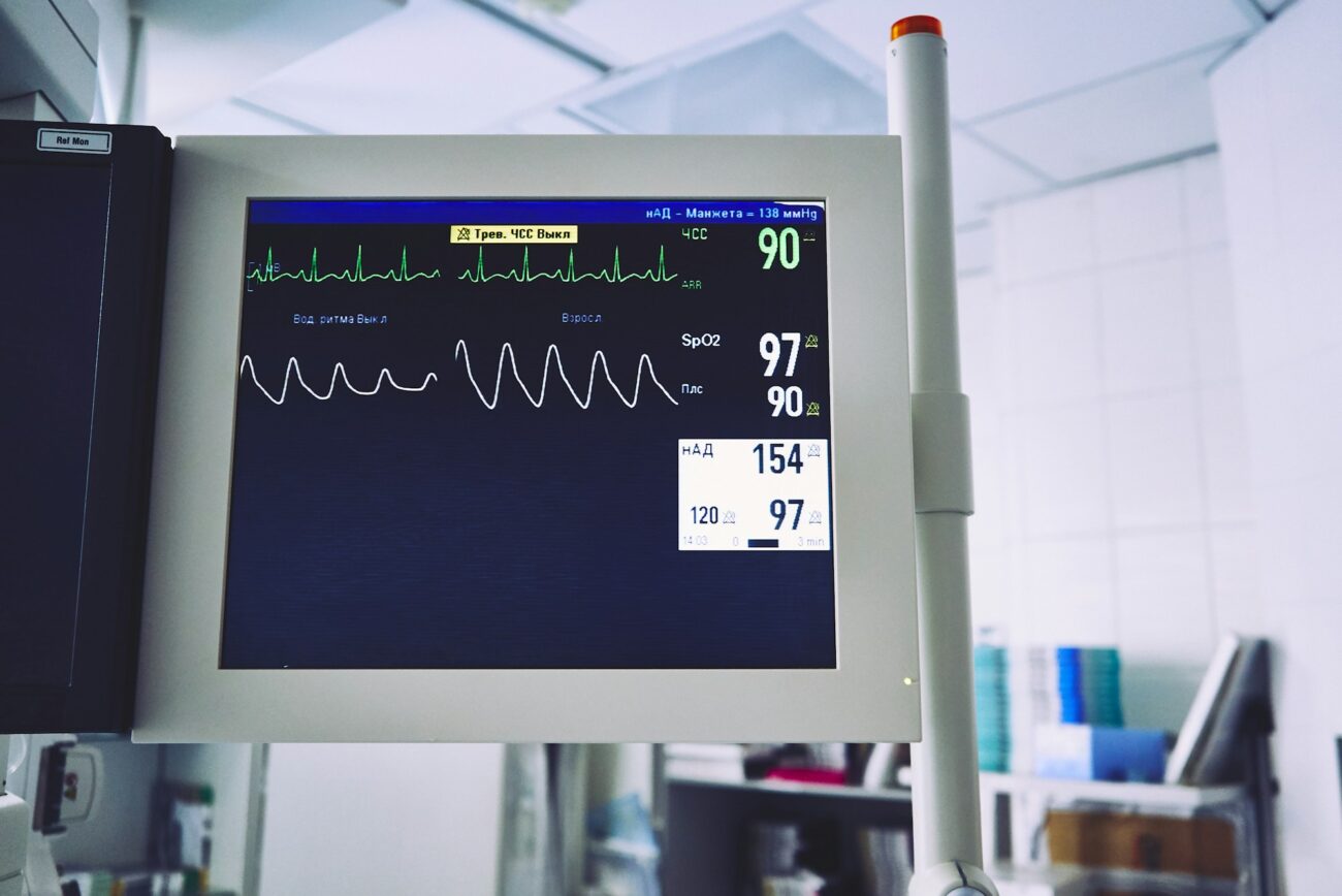 A hospital bedside monitor showing heart rhythm, oxygen saturation and a pulse waveform